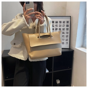 Detailed mirror selfie showing apricot faux leather tote bag capacity and fit on a model