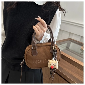 Detailansicht der braunen Mini-Boston-Bag aus Wildleder mit Bärenanhänger