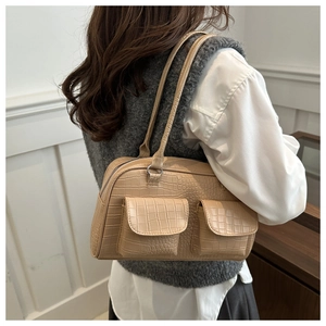 Detail of crocodile embossed faux leather shoulder bag with two front flap pockets