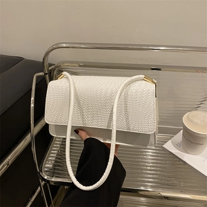 White shoulder bag with woven texture, minimalist design and golden hardware detail
