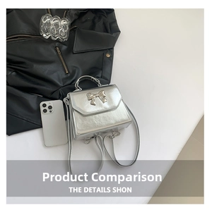 Detail of silver metallic PU leather handbag with decorative metal bow and top handle
