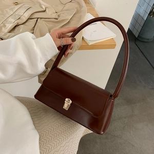 Donkerbruine baguette tas van kunstleer met gouden gesp en lange schouderriem detail