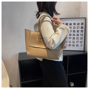 Detailed view of khaki leather tote bag with long handles and matte texture finish