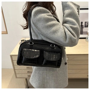 Close-up of black crocodile pattern shoulder bag featuring dual front flap pockets