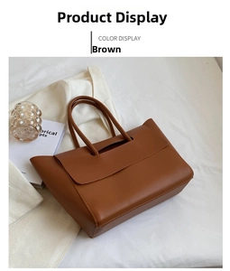 Detailed close-up of brown textured leather tote bag on white fabric in lifestyle setting