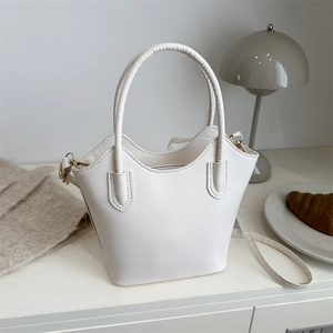 Minimalist white PU leather bucket bag with wavy rim design and gold metal hardware