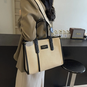 Grand sac cabas en toile beige avec bordure en cuir noir et bandoulière tissée