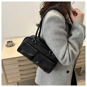 Detail of vintage black faux crocodile leather shoulder bag with double front flap pockets