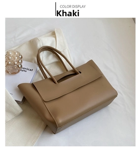 Detail view of khaki minimalist leather tote bag with smooth texture and double handles