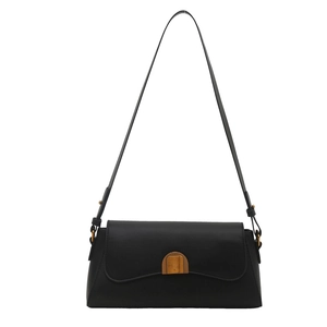 Sac sous le bras minimaliste en cuir noir avec boucle dorée élégante sur fond blanc