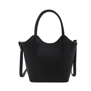 Minimalist black bucket handbag with gold hardware and dual handles on white background