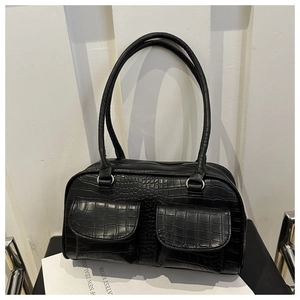Detail of black crocodile texture shoulder bag with dual front pockets and zip closure