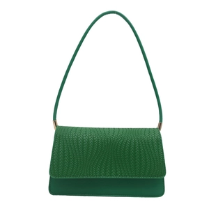 Minimalist emerald green shoulder bag with woven texture lid and golden metal accents