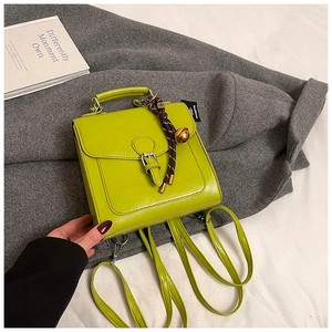 Dettaglio borsa in pelle verde neon lucida con etichetta BALENCIAGA e ciondolo decor