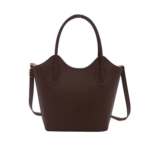 Minimalist brown leather tote bag with wave-edge design and adjustable shoulder strap