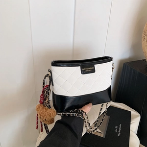 Quilted rhombus shoulder bag in black and white contrast with a cute bear charm