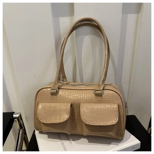 Detail view of beige crocodile embossed tote bag with double front pocket design