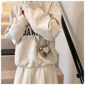 Detailed view of silver heart-shaped box bag with geometric diamond-cut design and chain strap