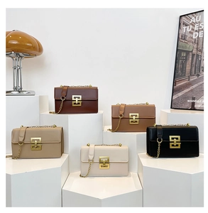Cinq sacs à bandoulière tendance en plusieurs couleurs exposés sur des supports géométriques