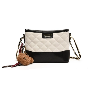 Sac seau matelassé noir et blanc minimaliste avec chaîne dorée et breloque ours