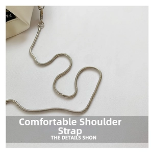 Detailed close-up of a white leather shirt-shaped bag featuring a sleek silver snake chain