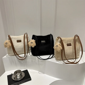 Chic fuzzy tote bag in ivory, black, and khaki with a plush bear charm and leather straps