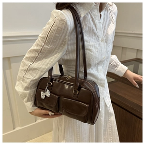 Detail der dunkelbraunen Vintage-Schultertasche mit Doppel-Fronttaschen und Silber-Schleife