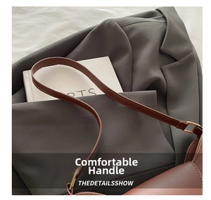Close-up of brown leather handbag featuring sleek texture and gold square metal buckle detail