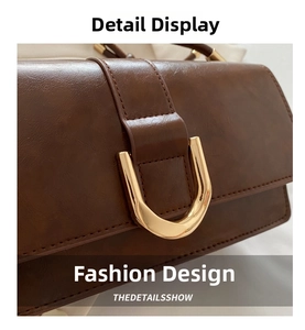 Dettaglio borsa vintage in pelle marrone con fibbia in metallo dorato a forma di ferro di cavallo