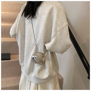 Close-up of metallic fish-shaped crossbody bag with detailed silver scales and chain