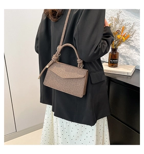 Detail of vintage brown houndstooth crossbody bag with knotted handle on a model