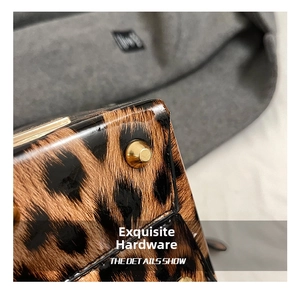 Macro detail of leopard print bucket bag featuring glossy finish and gold metal bottom studs