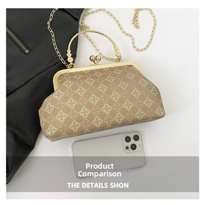 Retro monogram shell handbag with gold metal handle and chain strap shown with a phone
