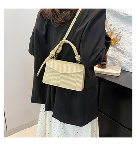 Straw flap bag with knotted handle detail shown as crossbody on female model