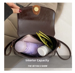 Internal capacity of brown leather saddle bag showing phone, umbrella, and sunglasses