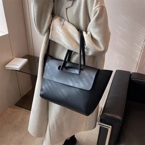 Minimalist black matte leather tote bag with large flap design and structured top handle