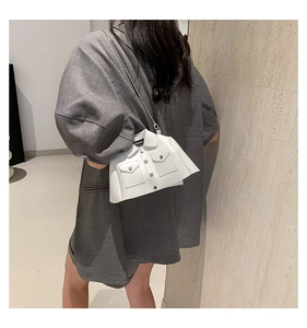 Detailed view of the white creative shirt-shaped shoulder bag worn by a model