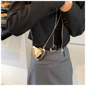 Close-up of golden geometric heart mini bag with luxury metal finish and thin chain strap