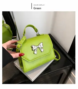 Close-up of bright green small square handbag with shiny silver metal bow decoration