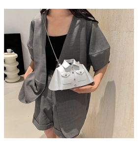 Detailed view of creative shirt-shaped white shoulder bag with metal chain on a model
