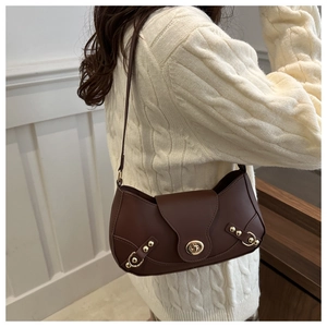 Deep brown leather underarm bag with gold metal clasp in a stylish crescent shape