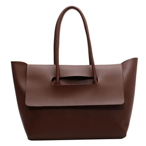 Minimalist large brown leather tote bag with unique flap closure for chic commuting