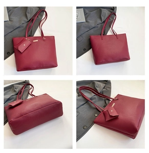 Macro details of wine red leather tote bag with lychee texture and gold-tone metal hardware