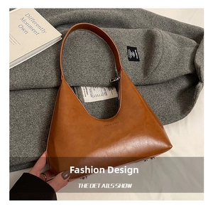 Detail of the vintage brown crescent shoulder bag with smooth faux leather and logo