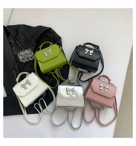 Detailed flat lay of mini bow crossbody bags in green, black, white, silver, and pink