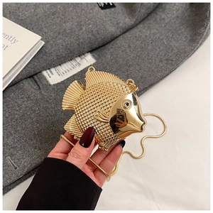Close-up of golden fish-shaped evening bag featuring detailed scales and metallic chain