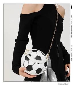 Fashionable soccer ball handbag with gold chain strap shown on a stylish model
