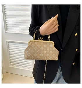 Detail of vintage beige shell bag featuring golden frame and floral pattern texture