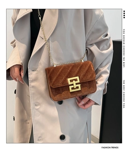 Détail du sac bandoulière en velours marron avec chaîne dorée et fermoir vintage