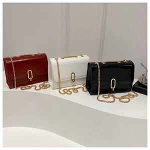 Detailed comparison of red, white, and black glossy chain crossbody bags with gold buckles